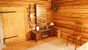 a room in a log cabin with a table and a door at Hubane seto talu ait in Leimani