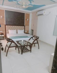 ニューデリーにあるHotel MARISA GRAND Near Delhi Airport BY Aero Homeのベッド、テーブル、ソファが備わる客室です。