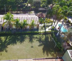Elle offre une vue sur une cour avec des palmiers et une piscine. dans l'établissement Hospedaria Monterrey, à Monte Mor