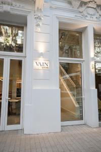 a white store front with glass doors and a staircase at Vain Boutique Hotel in Buenos Aires