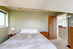 LopezにあるSunset View Houseの緑の壁に大きなベッドが備わるベッドルーム1室