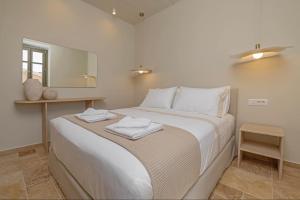a bedroom with a large bed with towels on it at Casa Alizeta in Halki