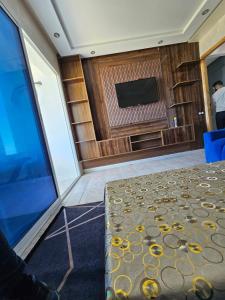 Zimmer mit einem TV, einem Tisch und einem Sofa in der Unterkunft la belle vue tanger R in Tangier