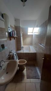 a bathroom with a sink and a toilet and a tub at Dimis-Apartment in Cologne
