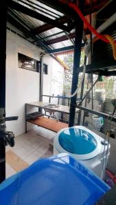 a bathroom with a toilet and a blue tub at Liturs Travel Services / Homestay / Rent a Car in Bacolod