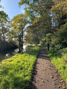 uma pessoa caminhando por um caminho ao lado de um rio em The Stable em Stourbridge