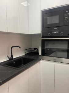 a kitchen with a sink and a microwave at Bela in Kumanovo +10 photos