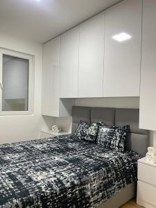 a bedroom with a bed and white cabinets at Bela in Kumanovo