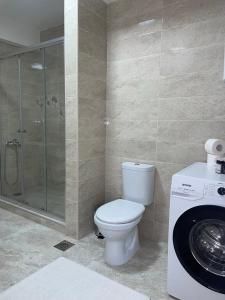 a bathroom with a toilet and a washing machine at Bela in Kumanovo