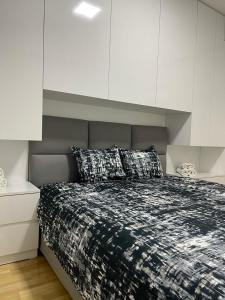 a bedroom with a large bed with white cabinets at Bela in Kumanovo
