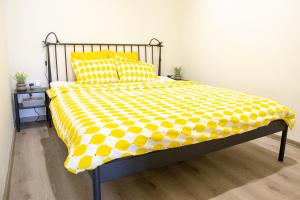 łóżko z żółto-białą kołdrą i poduszkami w obiekcie Apartmán Yellow Submarine se slunnou terasou w mieście Kutná Hora