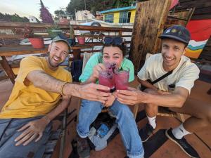 a group of three men holding up drinks at Casa Satoshi in San Cristóbal de Las Casas