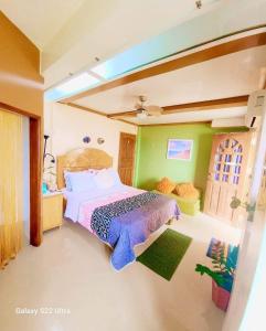 Libagon的住宿－CHUE&LARRY'S BEACHSIDE HOMESTAY，一间设有床铺的卧室,位于一个拥有绿色墙壁的房间