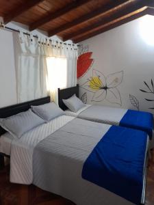 two beds sitting next to each other in a bedroom at La Cabaña Eco Hotel in Suaita