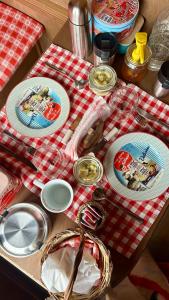 una mesa con placas en un paño de mesa blanco y rojo en Glamping Il Rifugio dei Marsi en Ascoli Piceno