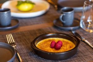 a bowl of food with two raspberries on a table at DIAGONAL HOTEL in Tangier