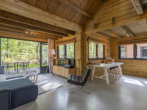 Sala de estar de una cabaña de madera con mesa y sillas en Amaryllis, en Soesterberg