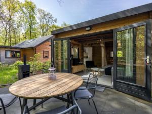 a house with a wooden table and chairs on a patio at Amaryllis in Soesterberg