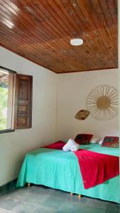 two beds in a room with a wooden ceiling at Pousada Canto do sabiá Imbassaí in Imbassai
