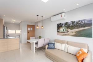 a living room and kitchen with a couch and a table at Vista Linda Eco Resort Carneiros in Tamandaré