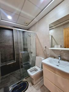 a bathroom with a shower and a toilet and a sink at Hotel Residence Ramsis in Nador