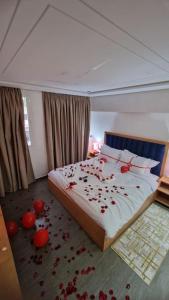 a bedroom with red rose petals on the floor at Hotel Residence Ramsis in Nador
