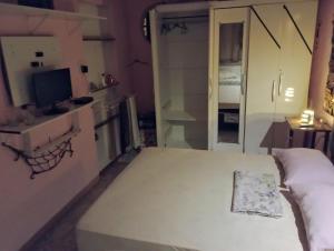 um pequeno quarto com uma cama e uma televisão em Pousada Lua Nua em Niterói