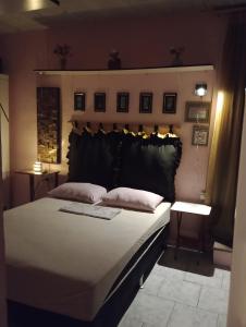 a bedroom with a large bed with a black headboard at Pousada Lua Nua in Niterói