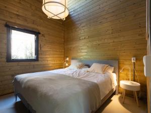 1 dormitorio con 1 cama en una pared de madera en Amaryllis, en Soesterberg