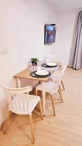 jadalnia ze stołem i białymi krzesłami w obiekcie Apartamenty "Pod Bocianim Gniazdem" w Myślenicach