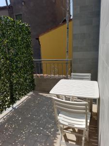 une table blanche et des chaises assises sur une terrasse dans l'établissement CHIOGGIA PLAYA, à Chioggia