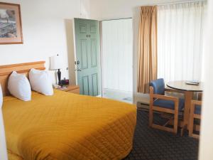Habitación de hotel con cama y mesa en Wild Rivers Motorlodge, en Brookings
