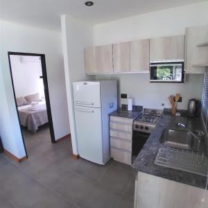 uma cozinha com um frigorífico branco e um lavatório em Casas del Lago em Potrero de Garay