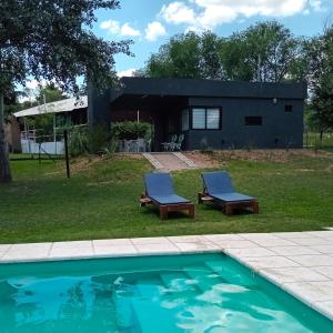 uma casa com uma piscina e duas espreguiçadeiras em Casas del Lago em Potrero de Garay