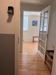 um corredor com uma porta para um quarto com pisos de madeira em 5 minute walk to LEGO house-70m2 apartment with garden-unit C em Billund