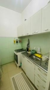 uma cozinha com armários brancos, um lavatório e um fogão em Apartment Copacabana Beach no Rio de Janeiro