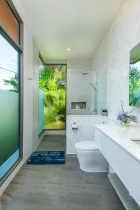 a bathroom with a tub and a toilet and a sink at Villa Mimosa 1, Splendid 4 Bedroom Master Ensuite in Phuket Town
