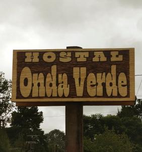 Un cartel de madera que dice "hostel oka ville" en Onda Verde Hostal in 