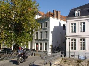 a man on a motorcycle parked in front of buildings at Apartment St-Anna in Bruges