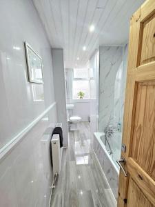 een badkamer met een douche, een toilet en een wastafel bij Spacious Haven with Free Parking in Glasgow