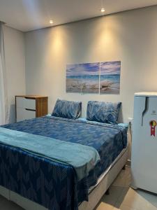 a bedroom with a bed and a refrigerator at Vila flores e mar in São Miguel do Gostoso