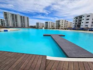 a large swimming pool with blue water and buildings at Mazatlán Bluu Condominio de Lujo con Laguna in Mazatlán