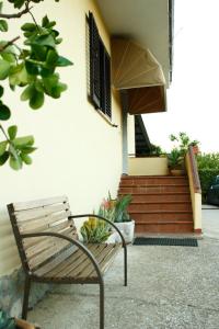 un banco de madera sentado frente a una casa en GuesthouseAntonia, en Avellino