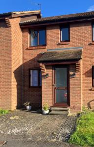 a brick house with a door with two plants at Lavender Cottage in Thirsk