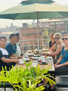 a group of people sitting at a picnic table at Hotel vintage Home in Bhaktapur