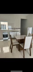een keuken met een tafel en twee stoelen en een tafel en een tafel en stoelen bij Apto Nossa Senhora Aparecida in Aparecida