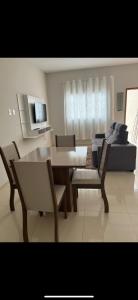 een woonkamer met een tafel, stoelen en een bank bij Apto Nossa Senhora Aparecida in Aparecida