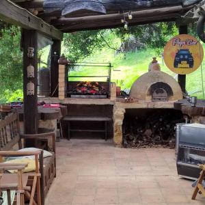eine Außenterrasse mit einem Pizzaofen und einem Grill in der Unterkunft Casa Heesen Mague in Susa