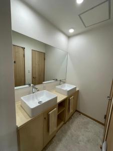 a bathroom with two sinks and a mirror at Koko in Fujikawaguchiko
