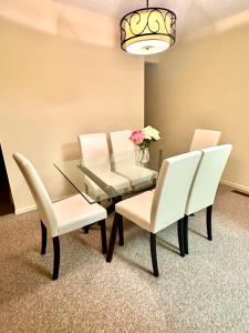 comedor con mesa de cristal y sillas blancas en Cozy private room in Edmonton en Edmonton